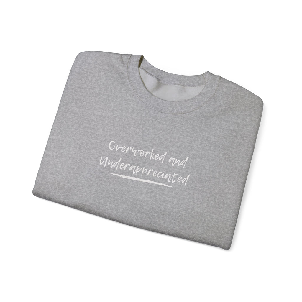 folded grey sweatshirt with text, overworked and underappreciated