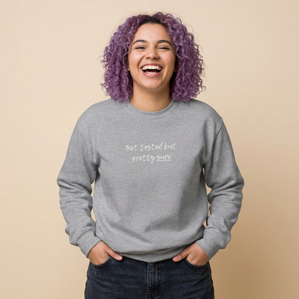 A person wearing a relaxed-fit "Not tested but pretty sure" sweatshirt in a studio setting. Comfortable, non-restrictive clothing for neurospicy adults and those navigating relatable chaos.