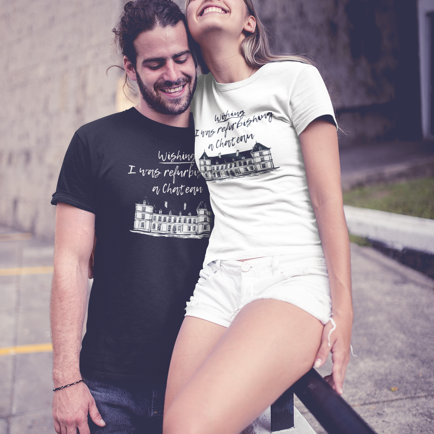 Two people wearing matching Pretty Bold Prints t-shirts with chateau logo wishing i was refurbishing a chateau  text standing outside and laughing