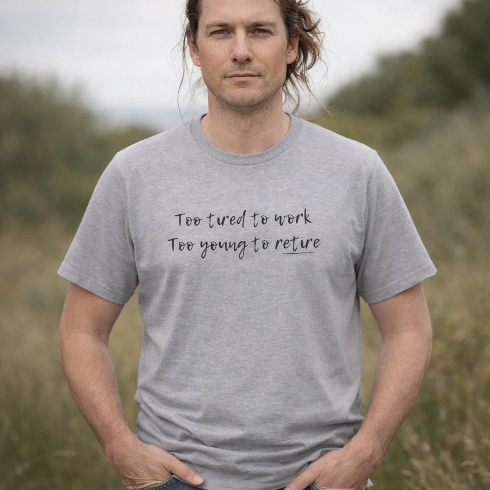 Man wearing a gray t-shirt with text in a field