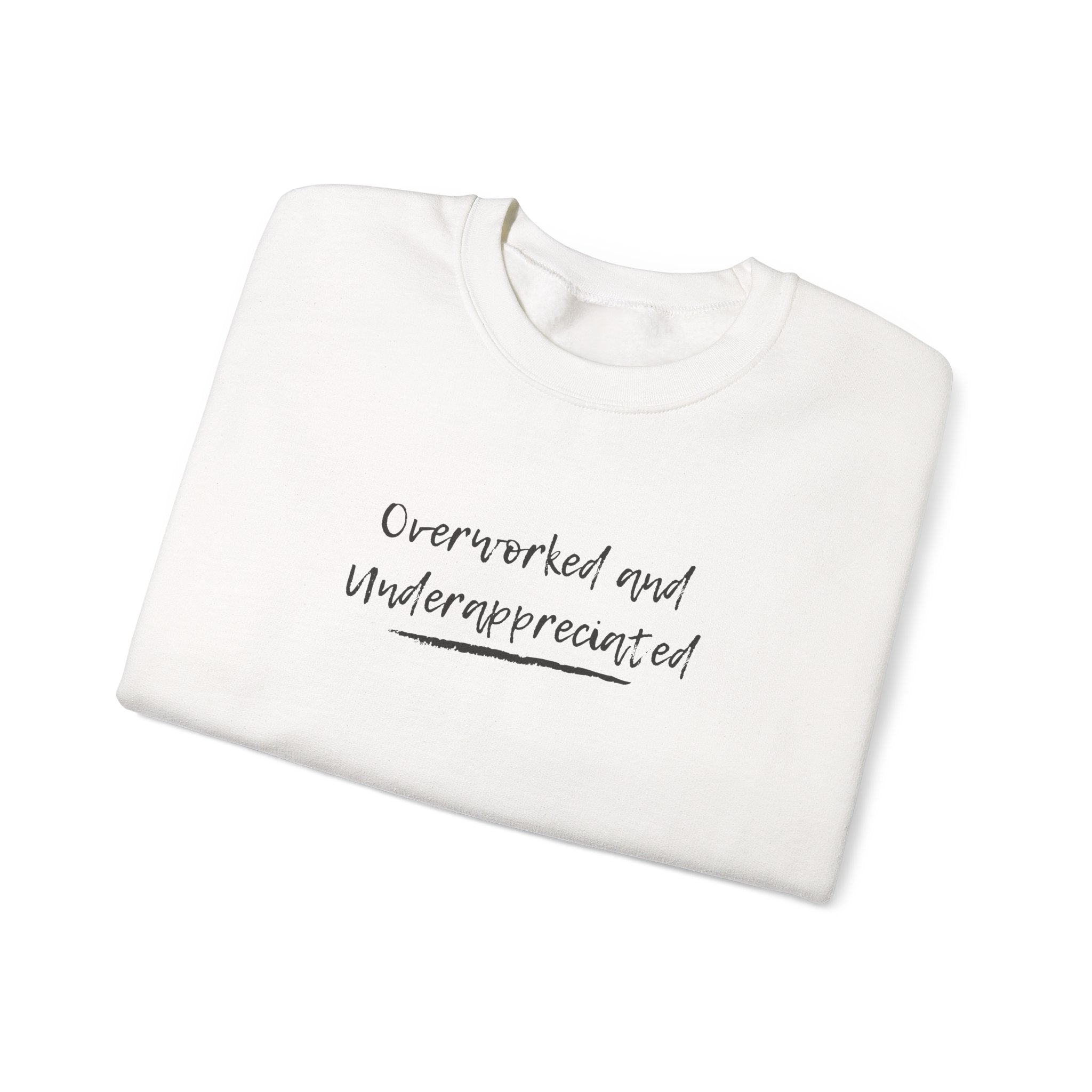 folded White sweatshirt with 'Overworked and Underappreciated' text on a white background