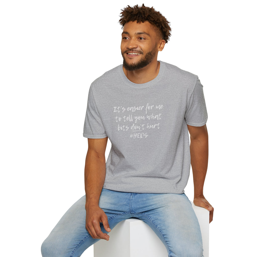Man wearing a gray t-shirt with heds quote sitting on a white stool.